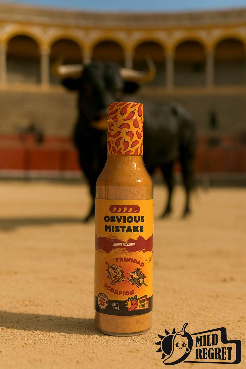 Mild Regret Obvious Mistake hot sauce in an arena with a bull in the background.