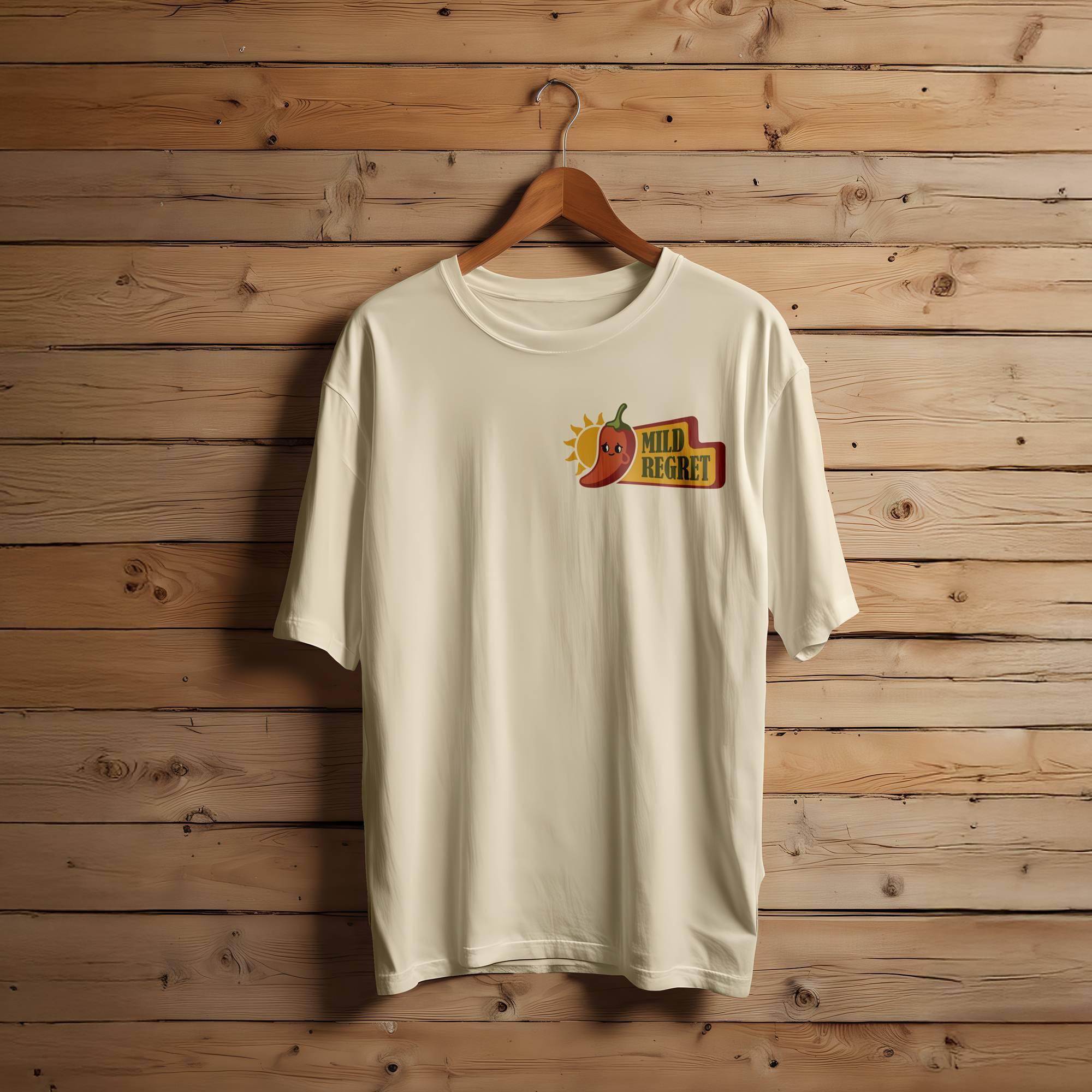A tan T-shirt featuring the Mild Regret logo in the upper corner.